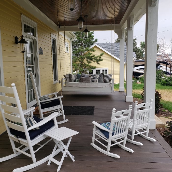White Chairs on Brown Deck in Backyard