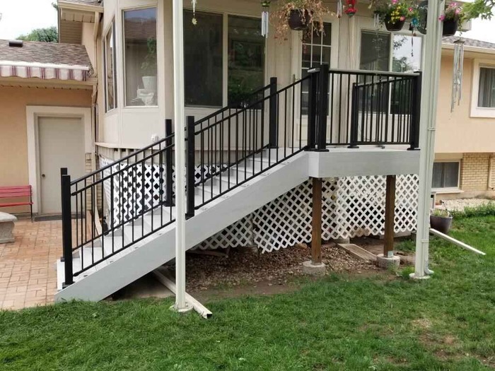 A patio with a metal railing and steps.