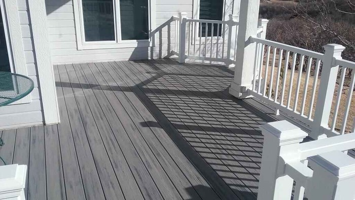 A deck with white railings and a table.